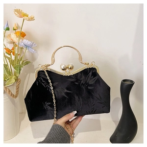 Detail of black velvet clutch with bamboo patterns, gold frame and double pearl clasp