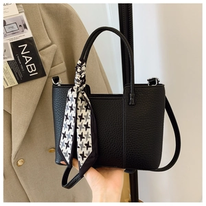 Close-up of black lychee grain tote bag with houndstooth silk scarf and shoulder strap
