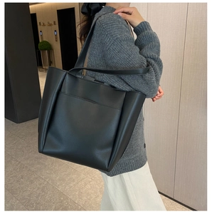 Detail of classic black tote bag side stitching and high-quality lychee grain leather texture