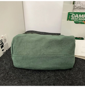 Gros plan d'un sac en toile vert foncé montrant les coutures et la texture du tissu