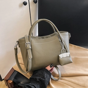 Sage green lychee leather bucket bag with contrast stitching and shoulder strap