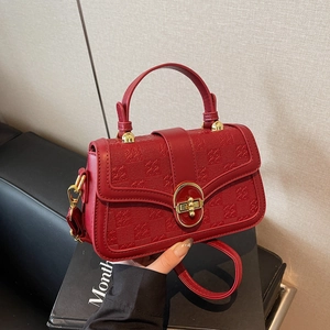 Red crossbody bag with checkered embossed texture and golden ring buckle handle