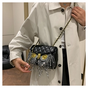 Detail of owl crossbody bag with rhinestone tassels and gold chain strap in close-up