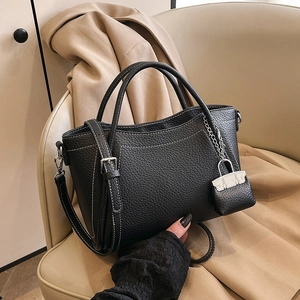 Black pebbled leather bucket bag with contrast white stitching and mini charm detail