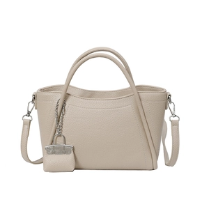 Large beige pebbled leather bucket bag with top handle and matching mini charm