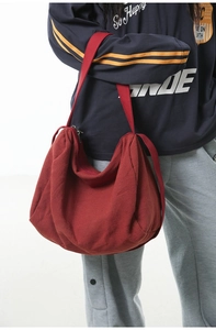 Détail d'un sac cabas rouge en toile avec texture naturelle et large bandoulière