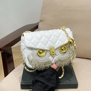 White owl-shaped crossbody bag with diamond quilting and gold tassel details