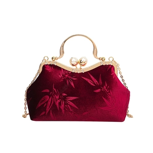 Vintage burgundy velvet handbag with bamboo pattern and pearl clasp on white background