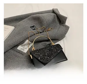 Detail of the black sequin crossbody bag with gold ring handle and metal chain strap