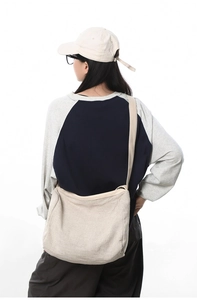Vue détaillée du grand sac bandoulière en toile montrant la texture et la fermeture