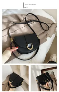 Détails du sac selle noir avec boucle en U dorée et finition en cuir mat élégant