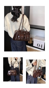 Detail of dark brown glossy patent leather shoulder bag with dual front buckle pockets