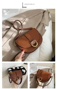 Détail du sac besace marron en cuir synthétique avec boucle fer à cheval dorée