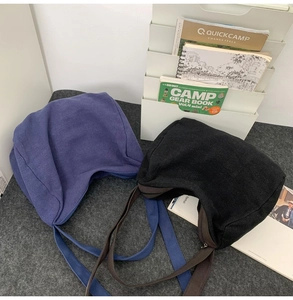 Sacs croissants en toile bleu marine et noir avec larges bandoulières sur fond en feutre