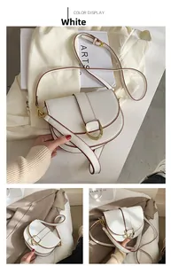 Détail du sac selle blanc avec boucle métallique dorée et bandoulière ajustable