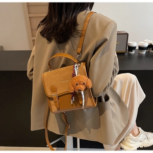 Borsa a mano vintage marrone con ciondolo a orsetto in un ambiente da caffè