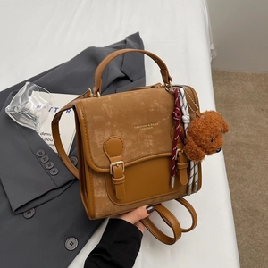 Zaino retrò marrone bicolore da donna con ciondolo a orsetto e manico alla moda
