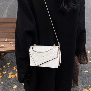 Elegant white leather crossbody bag with silver sequins and gold round metal handle