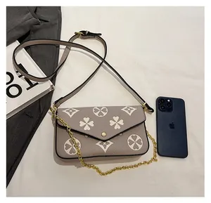 Detail view of the printed envelope shoulder bag size compared to a smartphone