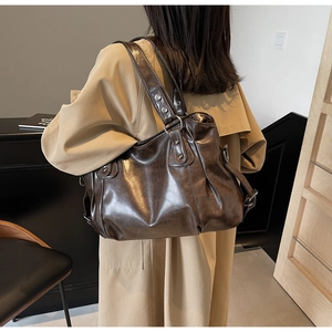 Détail du grand sac cabas en cuir marron foncé avec texture vintage et larges bandoulières
