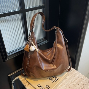 Retro brown leather hobo tote bag with baseball pendant and oval logo detail