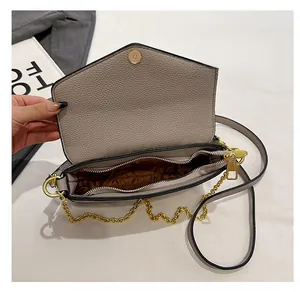 Detail view of the taupe crossbody bag showing internal compartments and brown lining