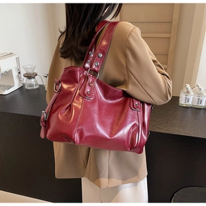 Détail d'un grand cabas bordeaux avec cuir plissé, rivets métalliques et doubles bandoulières