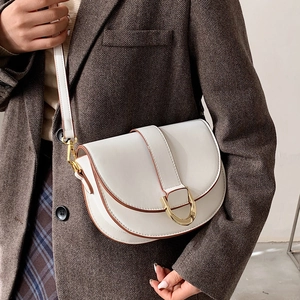 Sacoche blanche en cuir avec boucle dorée et bandoulière réglable portée par un mannequin