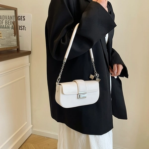 Detail of white PU leather handbag with silver clasp and metal chain strap for women