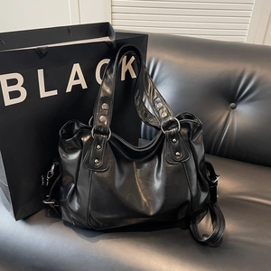 Grand sac cabas en PU noir brillant avec rivets argentés sur canapé en cuir