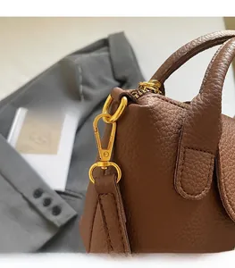 Nahaufnahme der dunkelbraunen Lederhandtasche mit edlen goldfarbenen Metallbeschlägen