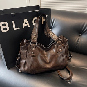 Grand sac cabas rétro en similicuir marron foncé avec rivets sur fond de canapé