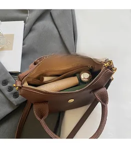 Innenansicht der braunen Lederhandtasche mit geräumigem Fach und goldenem Magnetverschluss