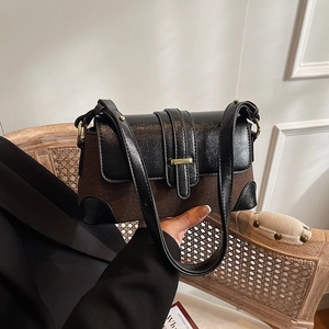 French vintage shoulder bag in black and brown contrast leather with gold metal buckle