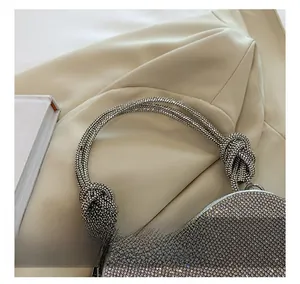 Vue détaillée du sac à main argenté en strass avec poignée nouée et cristaux brillants