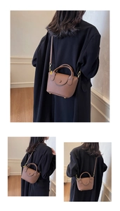Details einer braunen Lederhandtasche mit Lychee-Struktur und verstellbarem Gurt