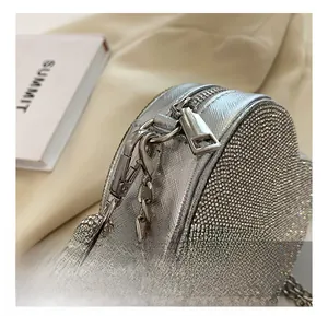 Gros plan sur le sac de soirée en forme de cœur avec strass argentés et chaîne en métal