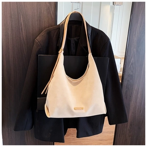 Close-up of beige frosted leather hobo bag with adjustable strap and gold brand plaque