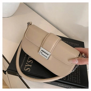 Detail of minimalist beige leather shoulder bag with polished silver rectangular buckle