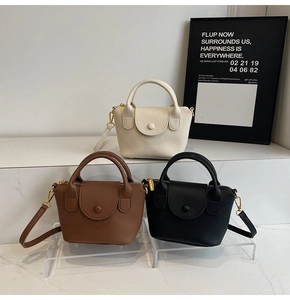 Moderne Mini-Handtaschen in Creme, Braun und Schwarz mit Litchi-Struktur auf Marmor