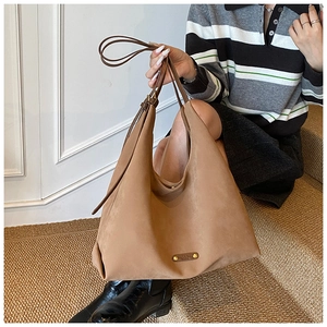 Close-up of khaki brown matte suede tote bag featuring a golden metallic logo plate