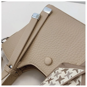 Detail of beige lychee leather bag with houndstooth silk scarf and silver hardware