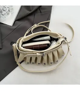 Spacious interior of beige pleated shoulder bag showing storage for phone and makeup