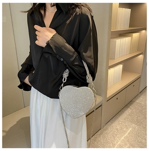 Gros plan du sac de soirée en strass en forme de cœur avec poignée torsadée et chaîne