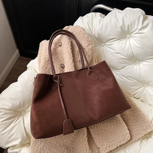 Large capacity dark coffee tote bag in matte suede texture on a cozy autumn background