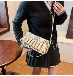 Detail of off-white pleated shoulder bag with punk metal eyelets and buckle strap
