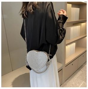 Détail du sac de soirée argenté en forme de cœur avec strass brillants et bandoulière