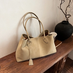 Large apricot suede tote bag with magnetic clasp on a vintage bench, minimalist style