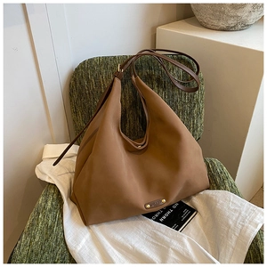 Detail shot of vintage mocha brown bucket bag on a chair showcasing matte leather texture