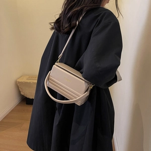 Minimalist beige box handbag with quilted stitching and adjustable shoulder strap for women